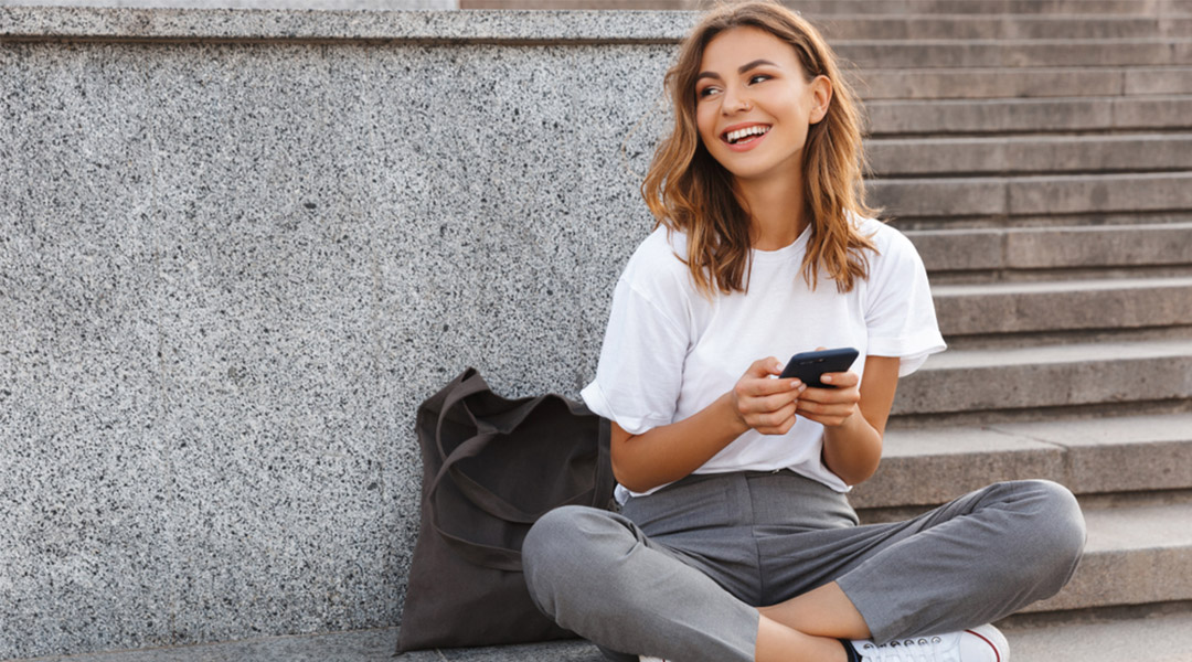 woman smiling and holding phone